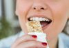 Person taking a bite of a granola bar