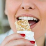 Person taking a bite of a granola bar