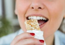 Person taking a bite of a granola bar
