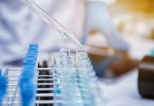 Pipette dispensing liquid into test tubes in a laboratory rack