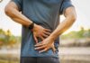 Painkiller Swap? Tiny Workouts Stun Scientists Person holding lower back in pain outdoors
