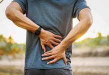 Painkiller Swap? Tiny Workouts Stun Scientists Person holding lower back in pain outdoors