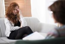 Most Therapists Miss THIS Biology Trap Woman with hand on forehead sitting on couch during counseling session