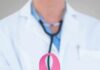 Doctor holding stethoscope with pink ribbon in front