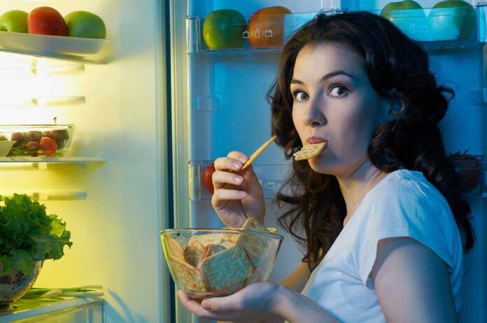 A,Hungry,Girl,Opens,The,Fridge Woman snacking at an open refrigerator