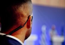 Association of Age-Related Hearing Loss With Physical Activity Security guard with earpiece watching a blurred event stage