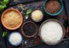 Assorted rice varieties in bowls on a dark tray