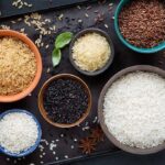 Assorted rice varieties in bowls on a dark tray