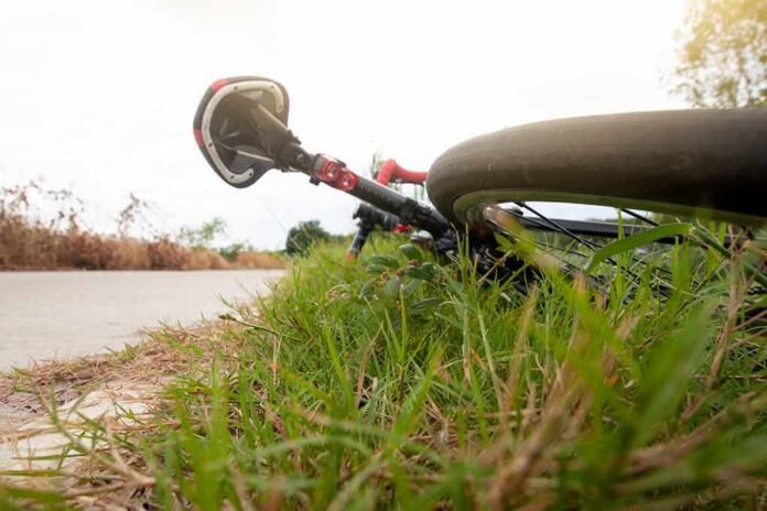 Road bicycle lying on grass beside a rural path