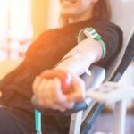 Person donating blood while squeezing a red ball