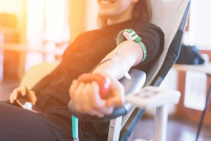 shutterstock_1245154153 Person donating blood while squeezing a red ball
