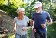 older couple jogging together in a sunny park