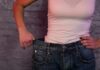 person in white tank top showing loose jeans waistband