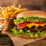 Cheeseburger with fries on rustic surface