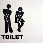 toilet sign with two figures crossing legs