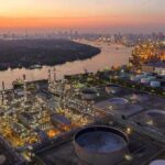 Industrial oil refinery complex beside a river at dusk