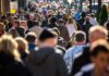 Crowd of people walking along a busy city street