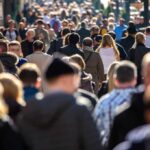 Crowd of people walking along a busy city street