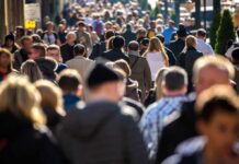 Crowd of people walking along a busy city street