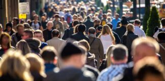 Crowd of people walking along a busy city street