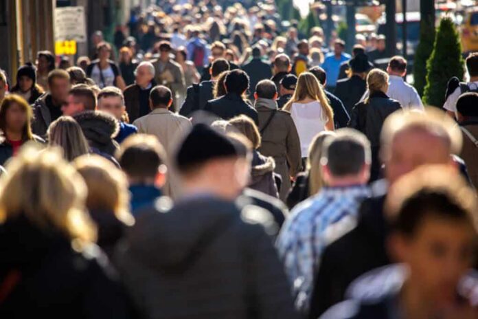 Crowd of people walking along a busy city street