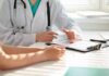 Doctors’ Notes: Patients Find Dangerous Errors Doctor discusses medical notes with patient at a desk