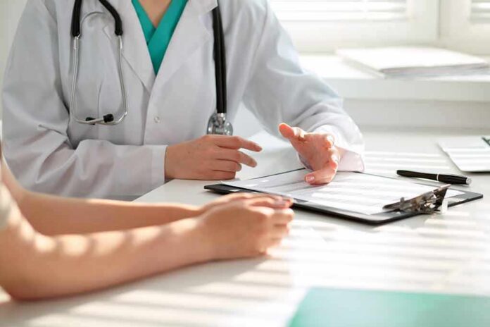 Doctor discusses medical notes with patient at a desk