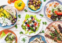Greek meze spread with salad, olives, pita, and grilled skewers