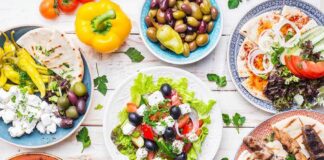 Greek meze spread with salad, olives, pita, and grilled skewers
