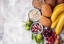 Assorted fruits, grains, bread, and nuts arranged on a gray surface