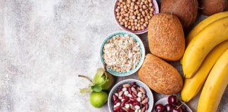 Assorted fruits, grains, bread, and nuts arranged on a gray surface