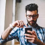 Man using smartphone by a window