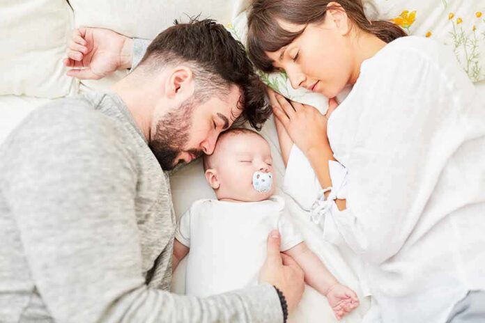 shutterstock_1247495608 Parents sleeping beside newborn baby