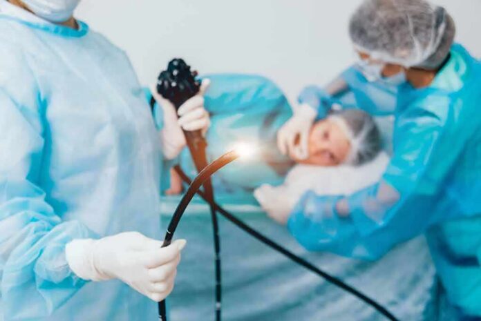 shutterstock_1275748081 Medical staff preparing endoscope near patient on hospital bed