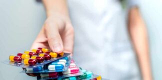 Hand holding blister packs of assorted capsules