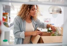 Woman unpacking groceries into a refrigerator