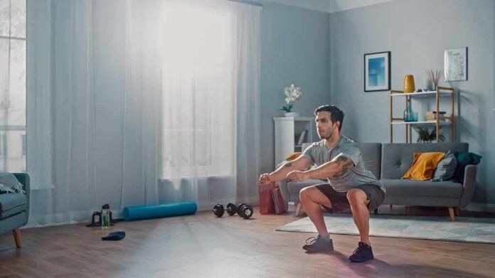 Man doing bodyweight squats in a living room