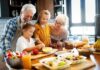 Grandparents and two children cooking together in a bright kitchen