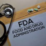 FDA document with stethoscope, pills, and pencil on envelope
