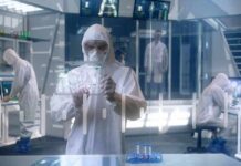 Mayo Builds ‘Smelling’ ER – What It Catches Scientist in hazmat suit using a transparent digital tablet in a lab