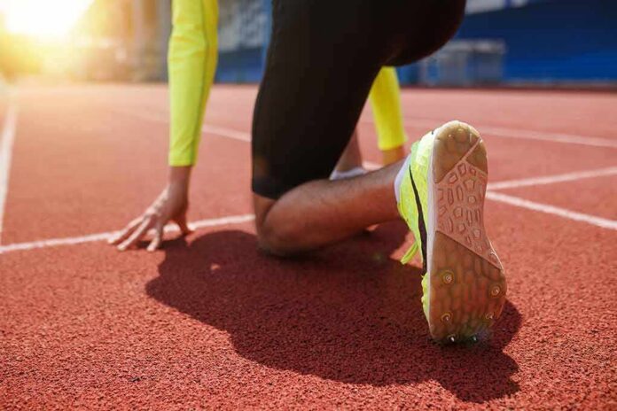 shutterstock_2467125607 sprinter at starting blocks on track