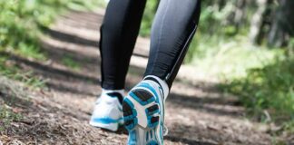 Runner's feet in athletic shoes on a forest trail