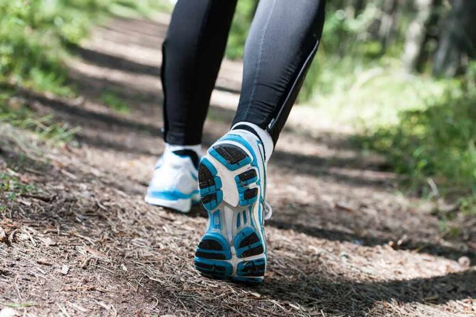 shutterstock_315937358 Runner's feet in athletic shoes on a forest trail