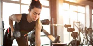 Woman performing dumbbell row in a gym