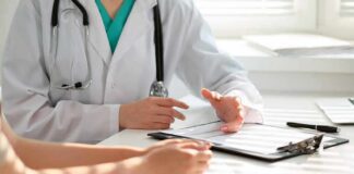 Doctor discusses medical notes with patient at a desk