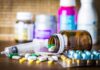 CDC Warning: Contraceptive Power Drained By Drugs Medicine pills and syringe on table with brown bottle
