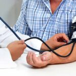 Patient getting blood pressure checked with a cuff and stethoscope