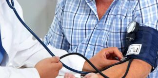 Patient getting blood pressure checked with a cuff and stethoscope