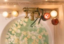 Sauna Trick Mimics a Workout Bathtub filled with water and white roses under candles